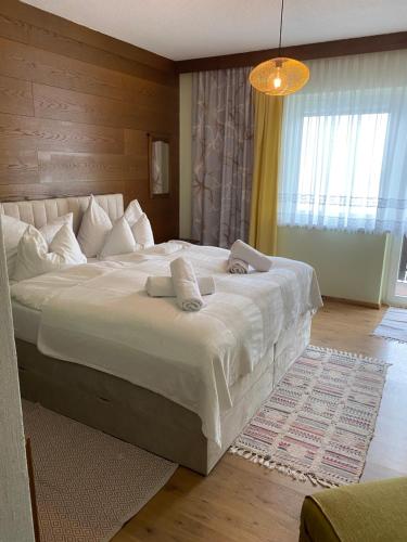 a bedroom with a large bed with white sheets at Gästehaus 3-Länderblick-Panoramablick in Mönichkirchen