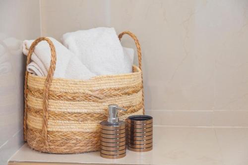 a basket with towels and a faucet in a bathroom at Newly renovated apartment with pool in Santa Cruz Huatulco