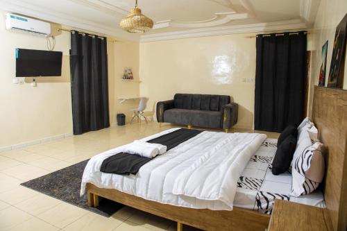 una camera da letto con un letto grande e un divano di AVS Résidence a Dakar