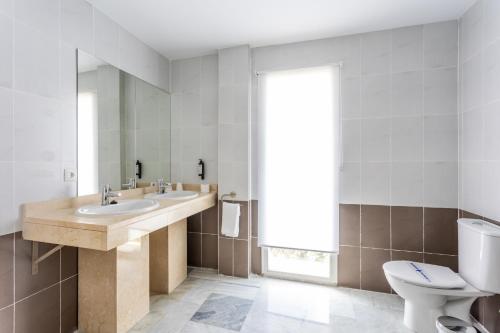 a bathroom with a sink and a toilet at Hotel El Tujjar in Los Barrios