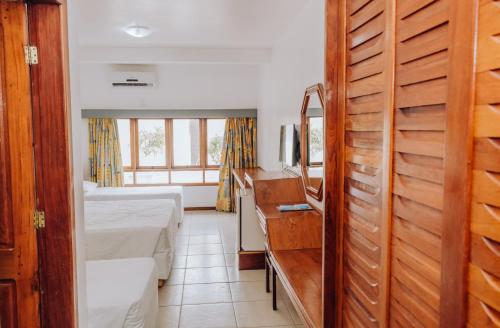 a small room with a bed and a television at Poty Praia Hotel in Porto Seguro