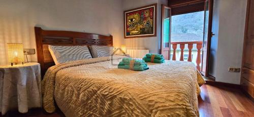 a bedroom with a bed with green pillows on it at La Casona y El Apartamento De La Foz in Lugar de Arriba