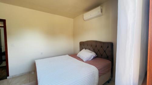 a small bedroom with a bed in a room at Jardim dos Ipês in Araranguá