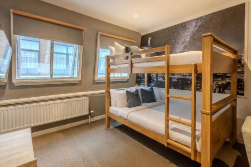 a bedroom with two bunk beds and two windows at Stewart by Heeton Concept - Aparthotel Edinburgh in Edinburgh