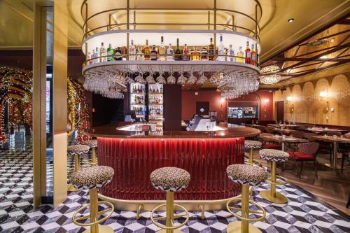 a bar with red chairs and a chandelier at Olympia Lis Baixa Hotel in Lisbon