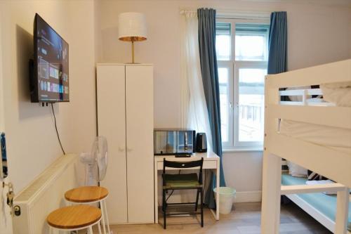 a bedroom with a desk and a bunk bed at Perfume Warehouse Stay in London