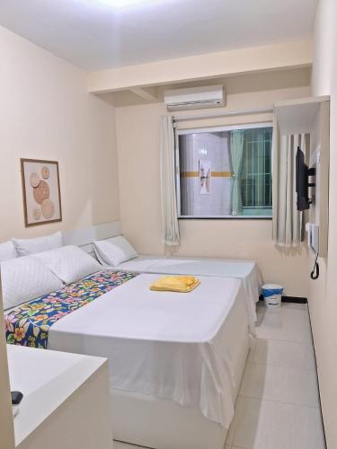 a bedroom with two beds and a window at Pousada Palladium in Neópolis