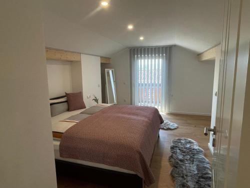 a bedroom with a large bed and a window at Charmantes Dorf-Apartment in Dietramszell