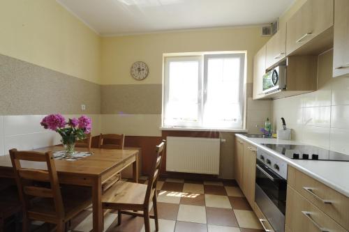 una cocina con una mesa con un jarrón de flores. en B&B vis a vis Zamku, en Malbork