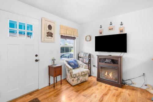 a living room with a fireplace and a flat screen tv at Easy Street Cottage in Rockaway Beach