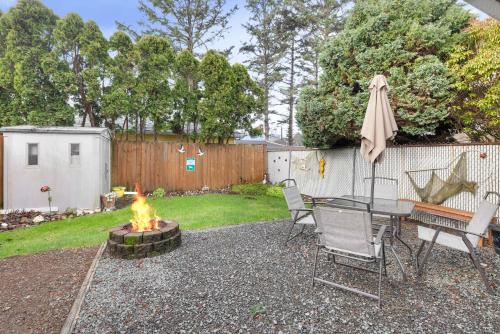a backyard with a fire pit and a table and chairs at Easy Street Cottage in Rockaway Beach