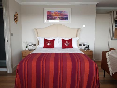 a bedroom with a large bed with red pillows at Anchors Aweigh in Stanley
