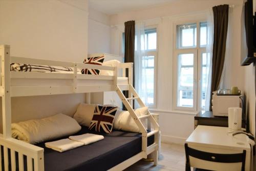 a bedroom with two bunk beds and a desk at Perfume Warehouse Stay in London