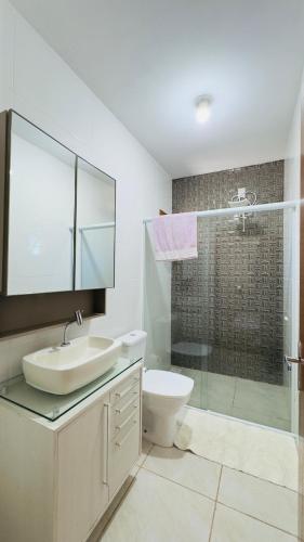 a bathroom with a sink and a toilet and a shower at Jardim dos Ipês in Araranguá
