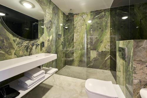 a bathroom with a shower and a toilet and a sink at Hotel AP in Kalisz