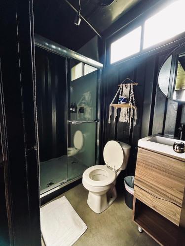 a bathroom with a toilet and a shower and a sink at Nomada Republic Hotel El valle in Valle de Anton