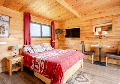 a bedroom with a bed in a wooden room at Gîtes Le Cerf de Belledonne in Sainte-Agnès
