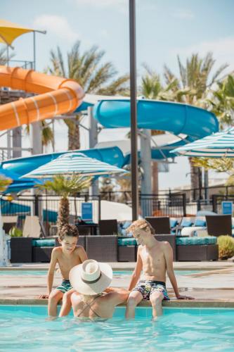 three young boys sitting in a swimming pool at Anaheim Resort Suites in Anaheim