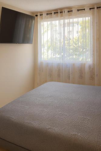 a bedroom with a large bed and a window at Two-bedroom condo Ground floor in Santa Cruz Huatulco