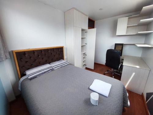 a bedroom with a bed and a desk and a chair at Marito in Juliaca