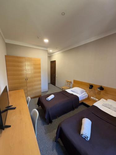 a hotel room with two beds and a desk at Art House Mestia in Mestia