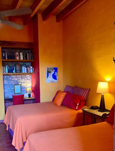 a bedroom with two beds and a book shelf at Posada de la cruz #4 in Querétaro