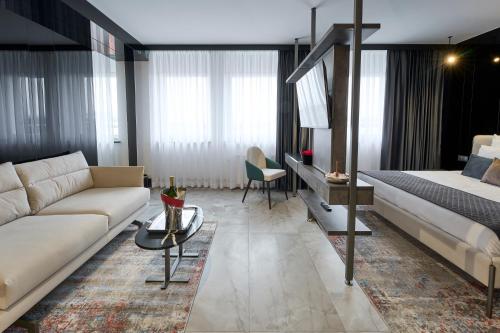 a living room with a couch and a bed at Hotel AP in Kalisz