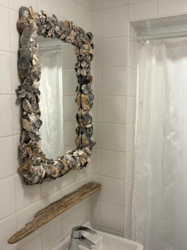 a bathroom with a mirror and a sink at PuraVida in Westkapelle