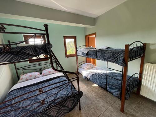 a room with three bunk beds in it at AETIA -TSIOURGIAKA MPATSILAS Group in Aetia