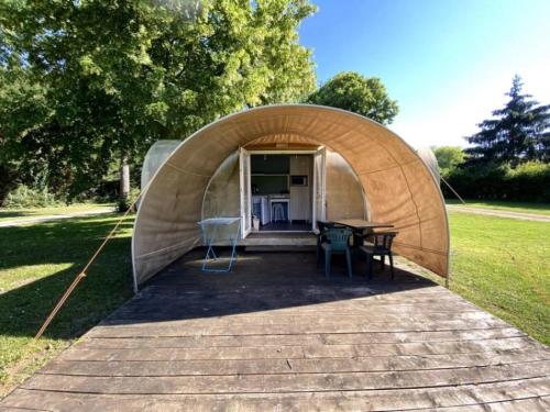 a tent with a table and chairs in a field at ZEcamping 3 étoiles animaux acceptés bar épicerie et restaurant in Auxonne