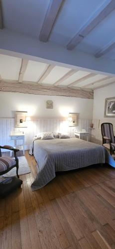 a bedroom with a large bed and two chairs at Moulin Notre Dame in Saint-Genès-de-Castillon