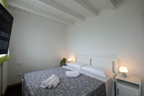 a bedroom with a bed with two towels on it at Lake-Hot Springs-Gardaland, Private Parking at Dolce Duplex Lazise in Lazise
