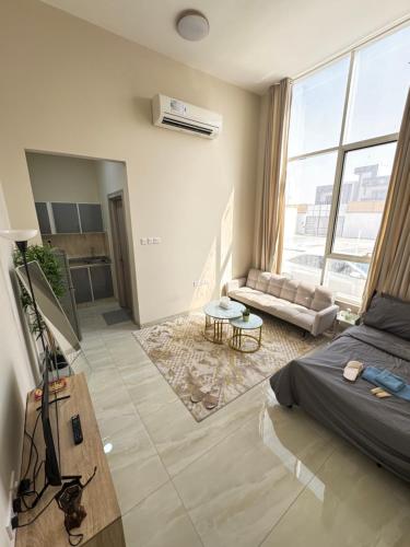 a bedroom with a bed and a living room at شروق للاستديوهات المفروشه in Abu Dhabi