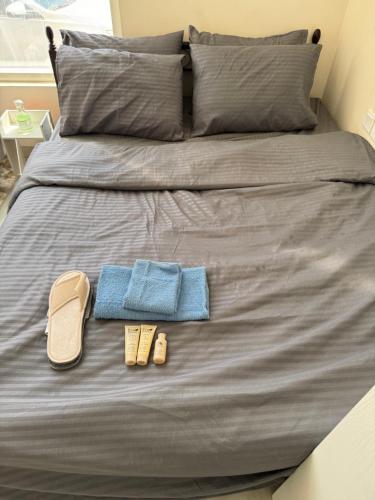 a bed with two pairs of shoes and towels on it at شروق للاستديوهات المفروشه in Abu Dhabi