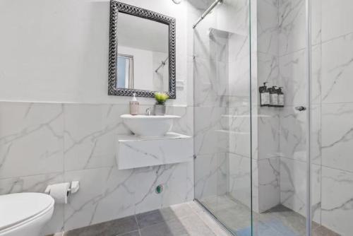 a white bathroom with a sink and a shower at Casa Payis Hotel in Cartagena de Indias
