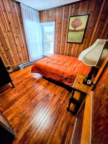 a bedroom with a bed in a room with wooden walls at Riverside Vista in Pulaski