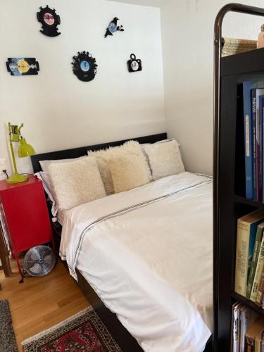 a bedroom with a bed and a shelf with clocks on the wall at Zurich Apartment I Central Loft in Zurich