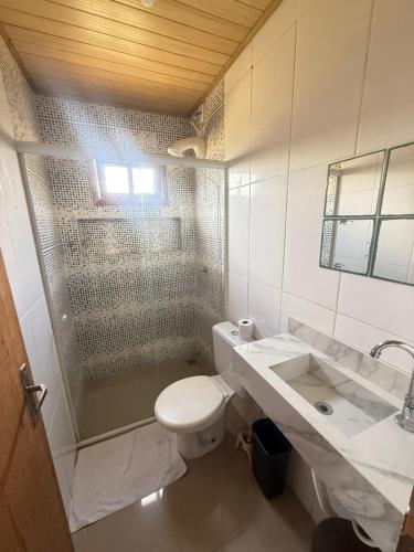 a bathroom with a shower and a toilet and a sink at Casa Buddha in Imbituba