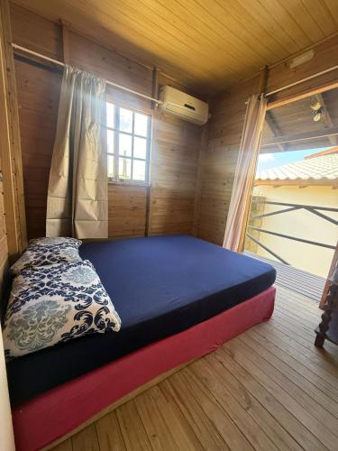 a bedroom with a bed in a wooden room at Casa Buddha in Imbituba