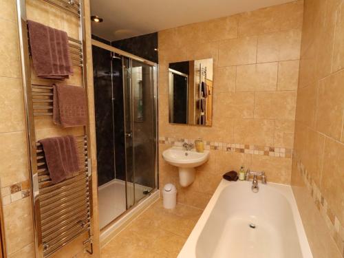 a bathroom with a bath tub and a sink at West Gate in Embleton