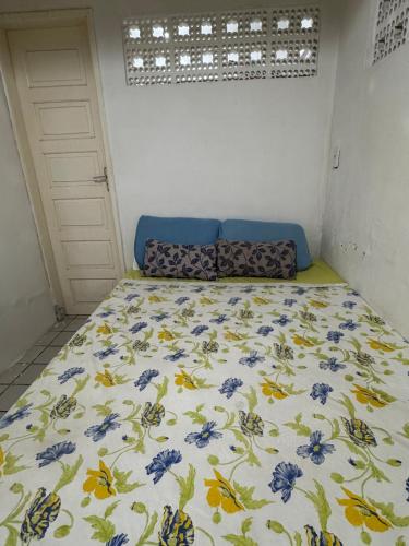 a bedroom with a bed with blue flowers on it at Casa com Piscina em Gravatá Carnaval in Gravatá