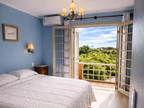 a bedroom with a bed and a large window at Golden Hills Vila Suzana in Canela