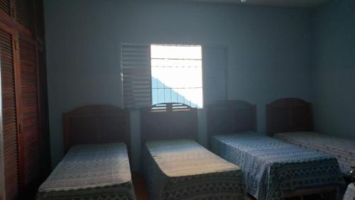 a small room with two beds and a window at casa azul in Itanhaém