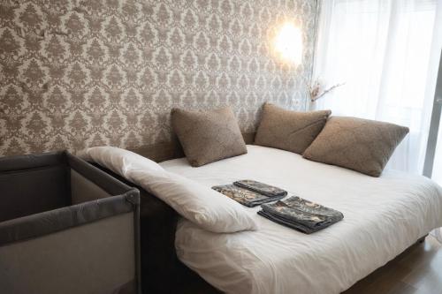 a bed with two pillows and two books on it at Friendly two-room apartment in Sigulda