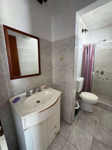 a bathroom with a sink and a toilet and a mirror at Departamento Centrico 2B in Gualeguaychú