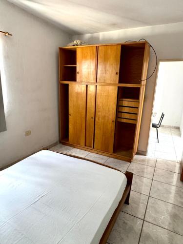a bedroom with a bed and a wooden cabinet at Departamento Centrico 2B in Gualeguaychú