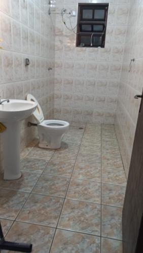 a bathroom with a toilet and a sink at casa azul in Itanhaém