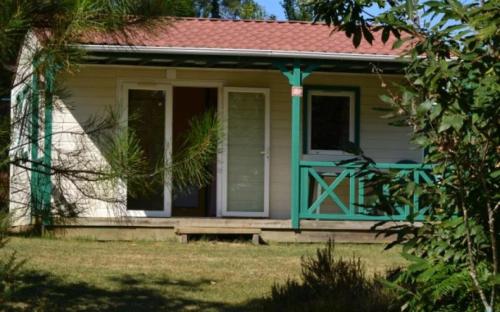 a small house with a green door and a porch at ZEcamping 4 étoiles animaux acceptés tennis pataugeoire in Tamniès