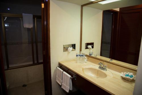 a bathroom with a sink and a large mirror at Hotel La Loma Tepic in Tepic