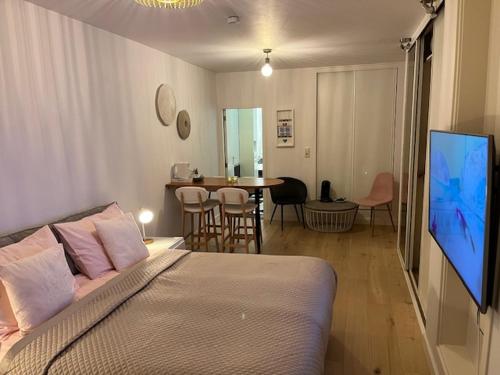 a bedroom with a bed and a tv and a table at Quarles 80 - free parking in Noordwijk aan Zee